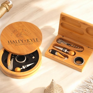 May include: A wooden box set with a personalized engraved lid that says "Haley + Kyle December 12, 2022". The box contains a bottle opener, a wine stopper, and a corkscrew.