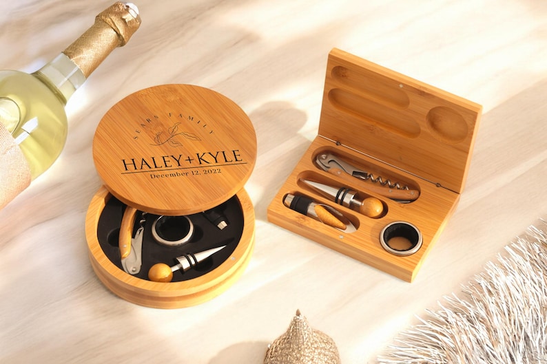 May include: A wooden box set with a personalized engraved lid that says "Haley + Kyle December 12, 2022". The box contains a bottle opener, a wine stopper, and a corkscrew.