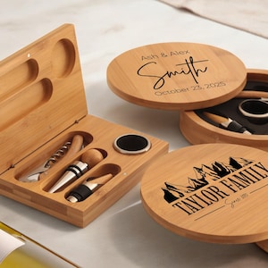May include: Two wooden boxes with engraved text. One box has the text "Ash & Alex Smith October 23, 2025" and the other box has the text "Taylor Family Since 1995". Both boxes contain a wine opener, a bottle stopper, and a foil cutter.