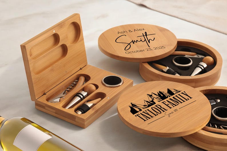 May include: Two wooden boxes with engraved text. One box has the text "Ash & Alex Smith October 23, 2025" and the other box has the text "Taylor Family Since 1995". Both boxes contain a wine opener, a bottle stopper, and a foil cutter.