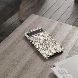 May include: A phone case with a cream background and black speech bubble graphics. Text includes "BECAUSE I SAID SO!", "AT YOUR GETABLES", "DO YOUR HOMEWORK", "DON'T TALK BACK", and "CALL ME WHEN YOU GET THERE".