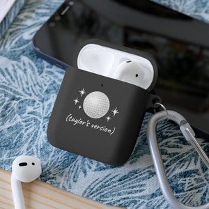 Apple airpod mirrorball case in black which says taylor's version in delicate font with a picture of a discoball as it is one of taylor swift's songs.