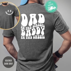 May include: Heather dark gray t-shirt with white text that reads "Dad in the streets Daddy in the sheets" in a retro font.
