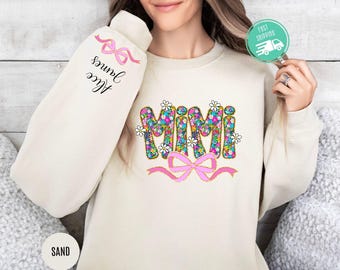 May include: A cream-coloured sweatshirt with the word "Mimi" in colourful floral letters and a pink bow. The sleeve has the text "Alice James" with a pink ribbon.