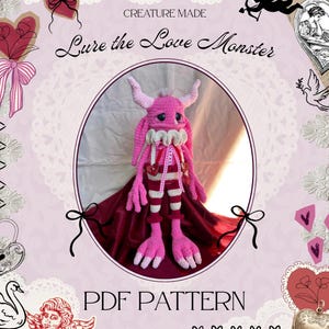Könnte beinhalten: Ein rosa gehäkeltes Monster mit Hörnern, einem Rüschenkragen und gestreiften Hosen. Das Monster hat einen traurigen Ausdruck und trägt einen roten Umhang. Der Text "Lure the Love Monster" und "PDF PATTERN" sind sichtbar.