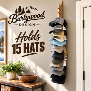 May include: A vertical wooden wall-mounted rack holding a stack of fifteen baseball caps in various colors including grey, black, tan, blue, and olive. The wall features the text Burlywood DESIGN Holds 15 HATS with a mountain and pine tree graphic.