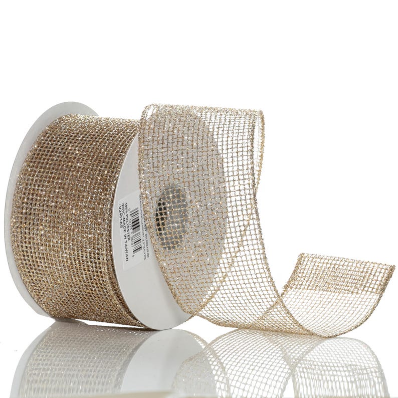 May include: A roll of gold mesh ribbon with a shimmering, open weave. The ribbon is on a white spool, and a length of the ribbon is unrolled, showing its texture and reflective quality. Ideal for crafts and gift wrapping.