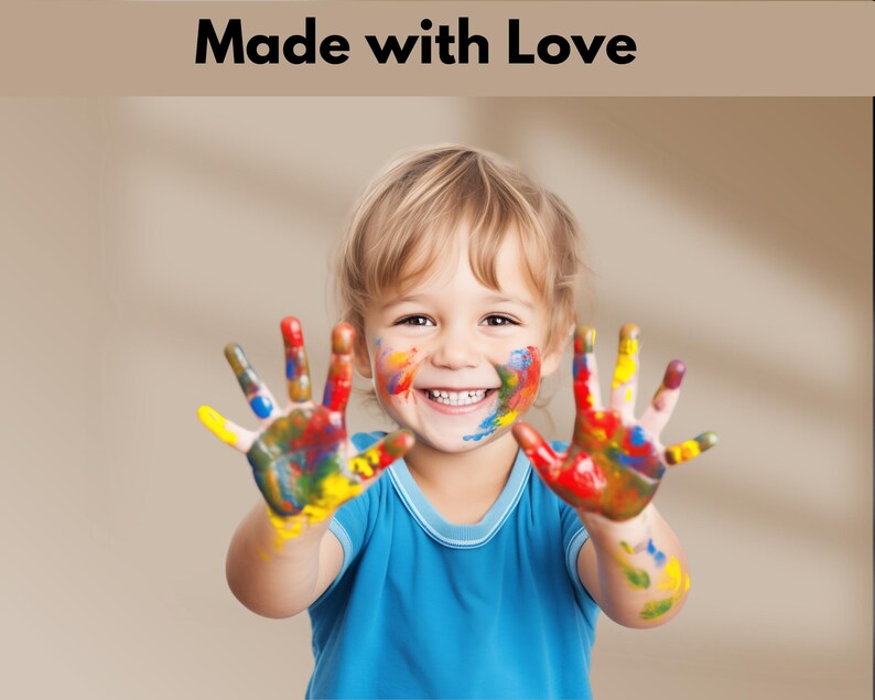 Peut inclure: Un jeune enfant avec de la peinture color&eacute;e sur les mains et le visage sourit &agrave; la cam&eacute;ra. L'enfant porte une chemise bleue.