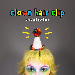 Könnte beinhalten: Ein gehäkelter Clown-Haarclip mit einem weißen Kegel, einem bunten Pompon und einem Regenbogen-farbenen Sockel. Der Text "clown hair clip crochet pattern" ist darüber abgebildet. Der Haarclip befindet sich auf gelbem Haar.