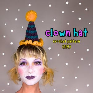 Può includere: Cappello da clown all'uncinetto con un pompon giallo, strisce turchesi e viola e un bordo a balze. Il testo "clown hat crochet pattern (PDF)" è visualizzato nell'immagine. Lo sfondo è grigio con stelle bianche.