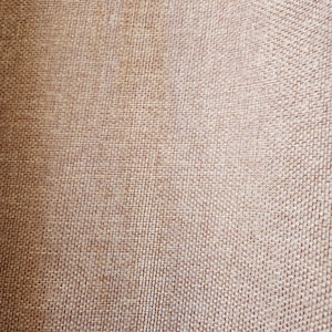 May include: Close-up of a brown woven fabric with a textured surface.