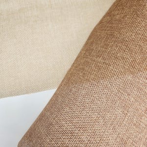 May include: Two pieces of woven fabric, one beige and one brown, with a textured surface.