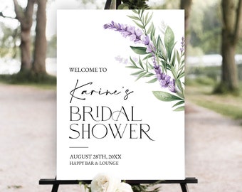 以下が含まれることがあります： 「Karine's Bridal Showerへようこそ」という黒い文字が書かれた白い看板。日付は「20XX年8月28日」、場所は「Happy Bar & Lounge」となっている。看板には、紫のラベンダーの花と緑の葉のウォーターカラーイラストが飾られている。