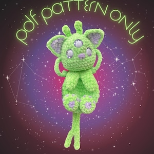 May include: A green crocheted alien cat with three eyes and a long tail. The cat is sitting with its paws crossed and its eyes closed. The background is a dark purple with white stars.
