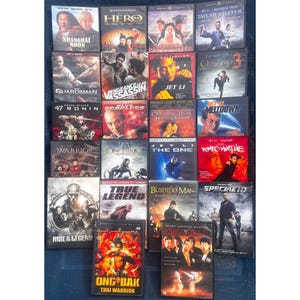 May include: A collection of action movie DVDs featuring martial arts themes. Titles include "Shanghai Noon," "Hero," "Ong Bak," and "Romeo Must Die." The covers display actors in action poses, with various color schemes and text.