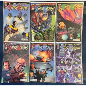 May include: A collection of six comic books titled "Shock Rockets." Each comic features vibrant, action-packed cover art with futuristic themes, including spaceships, explosions, and characters in space suits. The covers display issue numbers 1 through 6.