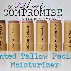 May include: Six brown cardboard tubes containing different shades of tinted tallow facial moisturiser. The tubes are labelled with the names: Ebony Elegance, Cocoa Charm, Golden Goddess, Bronze Beauty, Fairly Fabulous, and Pale & Posh. The text "Without Compromise Bath & Beauty Care" is at the top of the image. The text "Tinted Tallow Facial Moisturiser" is at the bottom of the image.