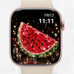 May include: A smartwatch with a rose gold frame and a beige band. The digital display shows the time 11:11 and the date FRI 13. The screen features a vibrant, faceted watermelon slice graphic with red and green crystals against a dark background.