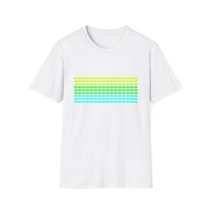 May include: White t-shirt featuring a repeating pattern of green, blue and yellow alien spaceships.