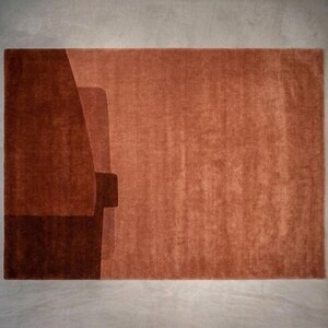 Rich rust terracotta geometric rug, dense wool pile, sculpted block edges for designer living spaces