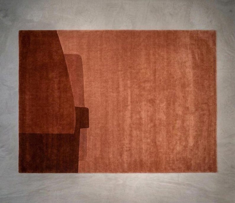 Rich rust terracotta geometric rug, dense wool pile, sculpted block edges for designer living spaces