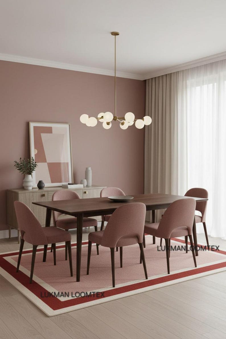 Blush dining room, chandelier over table, pink wool area rug with ivory and deep rose borders.