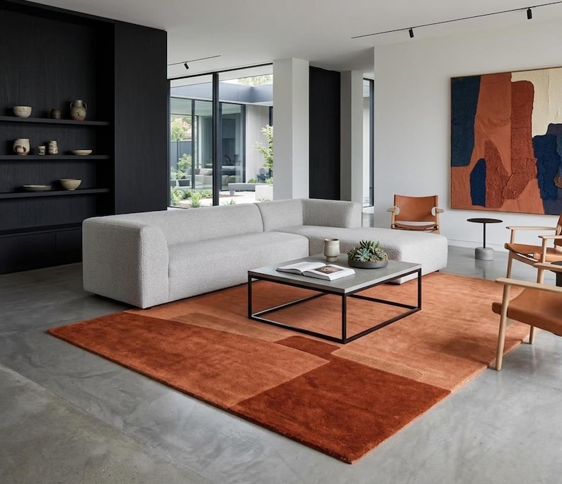 Modern living room scene, terracotta modern wool area rug under coffee table, mid century accents
