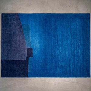 Vibrant blue modern wool area rug, bold color block composition, plush pile with carved boundaries