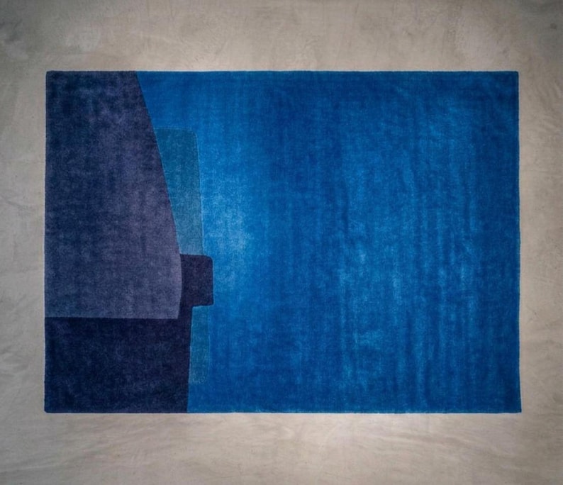 Vibrant blue modern wool area rug, bold color block composition, plush pile with carved boundaries