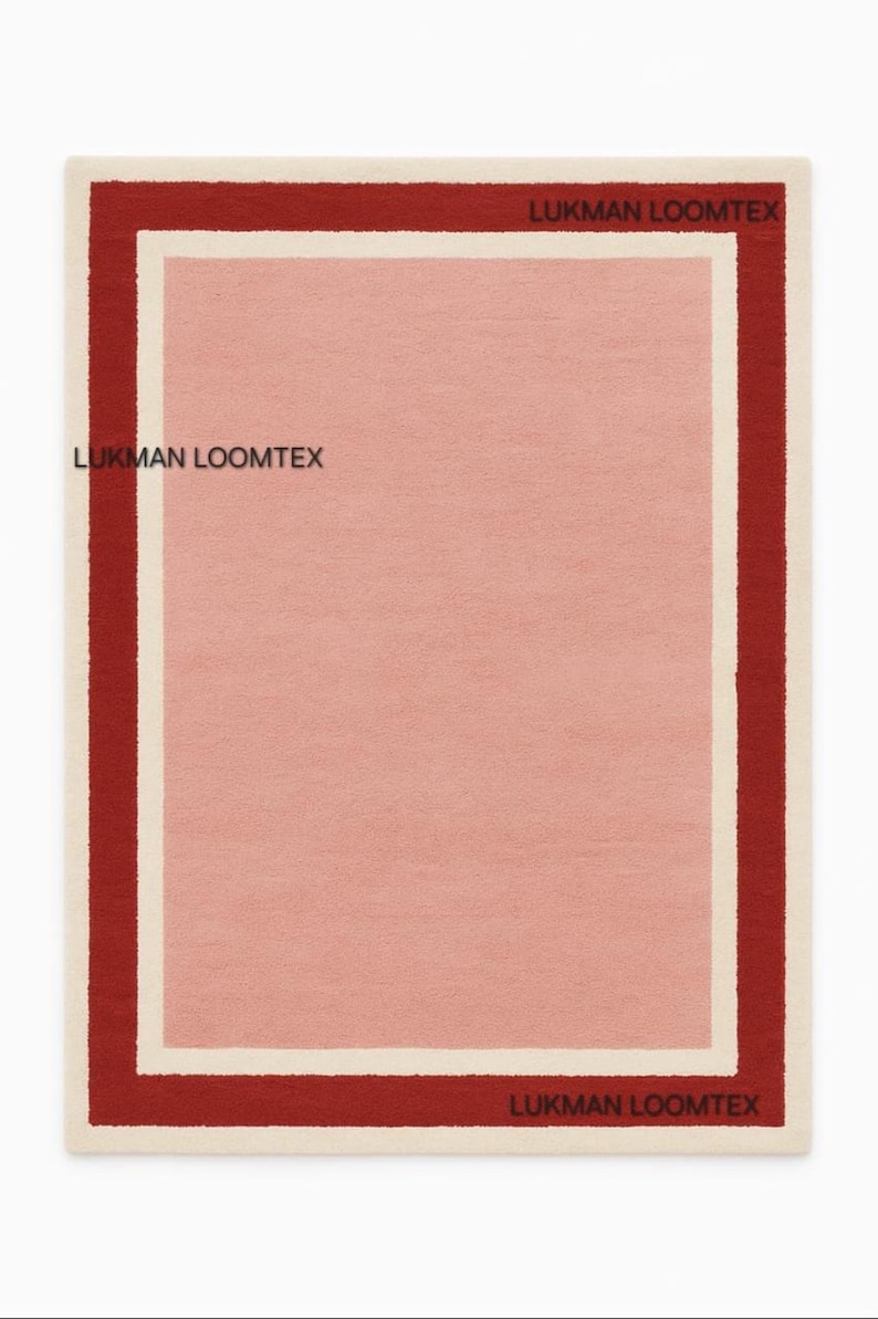 Flat lay showing hand-tufted pink wool area rug, rose center, ivory inner border, burgundy outer.