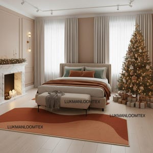 May include: A bedroom scene with a bed, bench, and area rug. The bed has a neutral headboard and is covered with a brown blanket and pillows. A Christmas tree is lit with lights. The rug has a wave design in shades of orange.