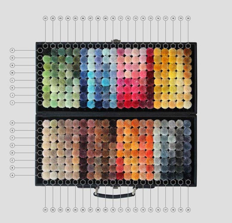 May include: A black case with a handle, open to reveal a collection of colorful carpet samples. The samples are arranged in a grid pattern, showcasing a wide range of hues from greens and blues to reds, oranges, and grays. Each sample is a small, textured square.