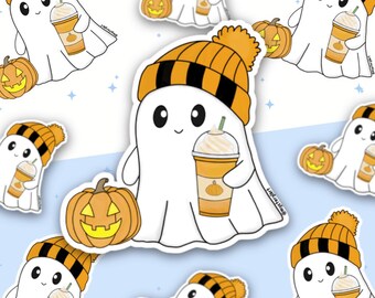 May include: A white ghost sticker featuring a smiling expression, wearing an orange and black striped knit beanie with a pom-pom. The ghost holds a plastic cup of orange beverage with whipped cream and sits next to a carved jack-o'-lantern.