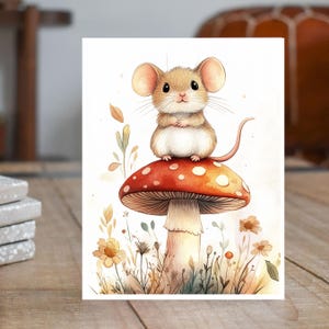 May include: A watercolor illustration of a cute mouse sitting atop a red mushroom with white spots. The mouse has large ears and a long tail. The mushroom is surrounded by flowers and foliage, creating a whimsical scene.