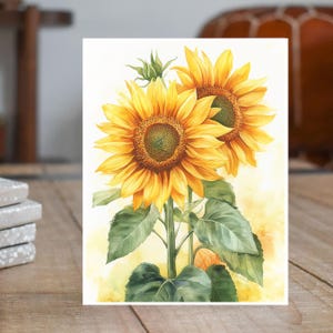 May include: A watercolor painting of two sunflowers with yellow petals and green leaves. The sunflowers are facing the viewer and are in bloom. The background is a light yellow.