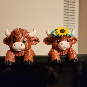 May include: A white ceramic mug with a black handle and the text "But First, Coffee" in a black, bold font. The mug is on a white surface.