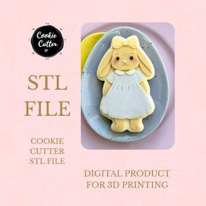 May include: A bunny-shaped cookie with a white dress and yellow bow, served on a gray plate. The image includes text that reads "STL FILE" and "DIGITAL PRODUCT FOR 3D PRINTING". The cookie cutter logo is also visible.