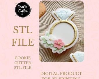 May include: A cookie cutter in the shape of a diamond ring, decorated with white icing, gold accents, and pink and white flowers. The image includes the text "STL FILE" and "DIGITAL PRODUCT FOR 3D PRINTING".