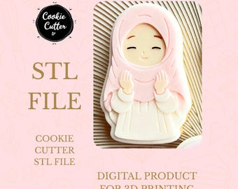 May include: A pink and white cookie cutter in the shape of a person wearing a hijab. The image includes the text "STL FILE" and "DIGITAL PRODUCT FOR 3D PRINTING". The cookie cutter is designed for 3D printing.