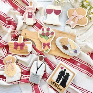 Hand-decorated pastel royal-icing sugar cookies in blush pink and ivory, artisanal gift cookies for weddings and Valentine's