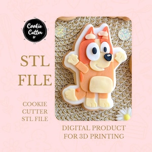 Puede incluir: Cortador de galletas con forma de perro de dibujos animados, con detalles en naranja, blanco y negro. La imagen incluye el texto "STL FILE" y "DIGITAL PRODUCT FOR 3D PRINTING". El cortador de galletas está sobre un fondo rosa.