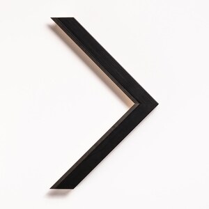 May include: Black picture frame with a simple, angled design. The frame is made of wood and has a matte finish.