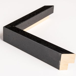 May include: Black wood picture frame with a simple, clean design. The frame has a smooth, matte finish and a subtle wood grain texture.