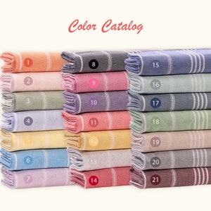 Stack of Turkish Beach Towels in various colors. Custom Logo Beach Towels featuring white stripes and tassels, perfect for bachelorette parties, beach days, poolside, camping, yoga, and personalized gifts. Perfect customizable gift for everyone.