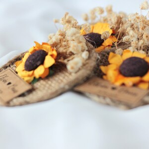 May include: Three small burlap and dried flower arrangements with a sunflower and a tag that says "Ellen & Paul" with a heart and the date "08.27.23".