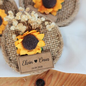 May include: Two burlap and brown paper favor tags with a sunflower and dried flowers. The tags are decorated with the text "Elwin &hearts; Onur 18.09.2020".