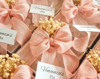 Bomboniere personalizzate con candele, nastri e targhette a forma di fiore di loto per matrimonio