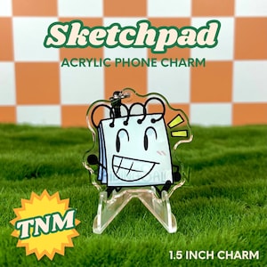 May include: A clear acrylic phone charm shaped like a smiling notepad character. The charm has black arms and legs, and the text "Sketchpad" and "Acrylic Phone Charm" are displayed in green. The charm is 1.5 inches in size.