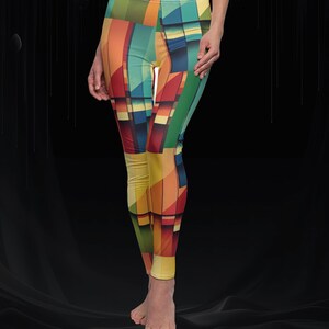 May include: Colorful leggings with a geometric pattern in shades of yellow, orange, red, green, and blue. The leggings have a high waist and a form-fitting design. The abstract design creates a modern and artistic look.