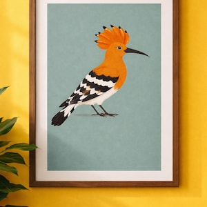 Puede incluir: L&aacute;mina enmarcada con una ilustraci&oacute;n estilizada de una abubilla. El ave tiene plumaje naranja, una cresta distintiva y un pico largo y curvo. El fondo es de color verde azulado apagado y el marco es marr&oacute;n c&aacute;lido.